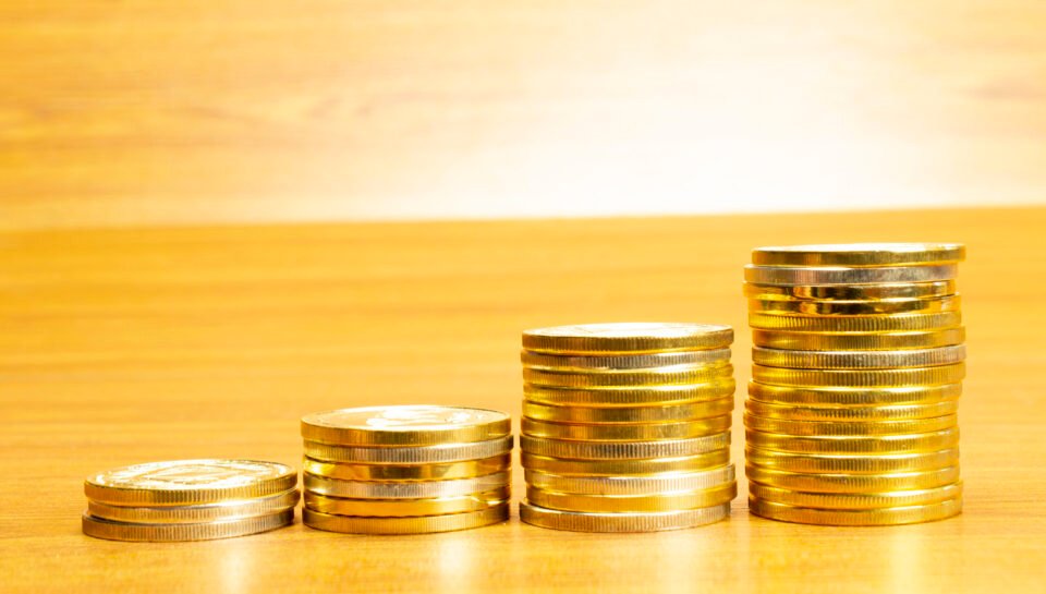 4 rows of coins arranged in ascending order with selective focus and blurred background. Growth concept.